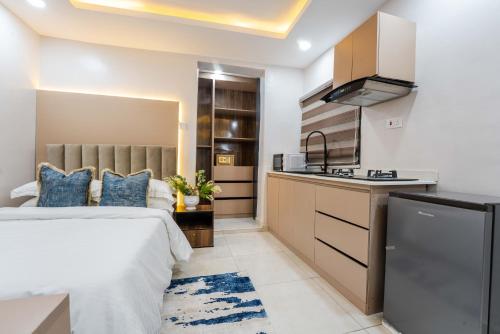 a hotel room with a bed and a kitchen at Sapphire Heights Apartment Single Rooms in Lagos