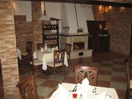 a dining room with a table and a fireplace at Hotel Villa Ofir in Sandanski