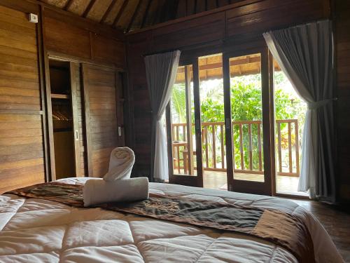 1 dormitorio con 1 cama con ordenador portátil en Mangrove Beach Hut, en Nusa Lembongan