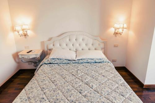 a bedroom with a large bed and two lights on the wall at Bed and Breakfast Villa Romano in Anzio