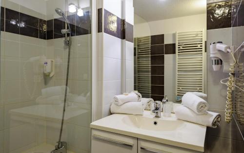 a bathroom with a sink and a shower at Lagrange Aparthotel Montpellier Millénaire in Montpellier