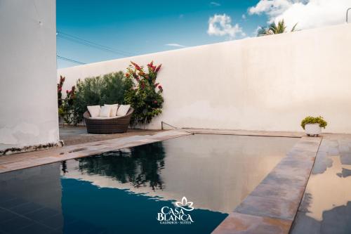 a swimming pool in front of a white wall at Casa Blanca in Galinhos