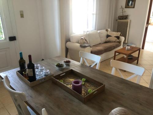 una sala de estar con una mesa con botellas de vino. en Al Mare Skyros, Fully-equipped house, en Skiros