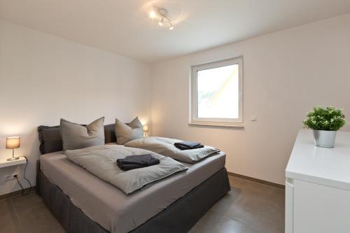 een slaapkamer met een bed met 2 kussens erop bij Apartment unter den Kiefern 109 in Röbel