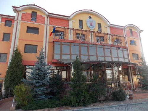 a large building with a balcony on top of it at Hotel Transit in Oradea