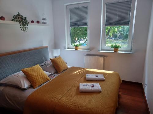 a bedroom with a bed with two towels on it at Apartament B & S - Free Garage Parking in Szczecin