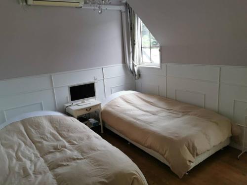 a bedroom with a bed and a desk with a monitor at Kitasaku District - Hotel - Vacation STAY 89259 in Kutsukake