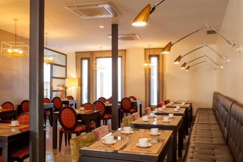 un restaurante con mesas de madera y sillas en una habitación en YIT El Postigo, en Úbeda