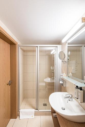 a bathroom with a shower and a white sink at Kerpė Hotel & SPA in Palanga