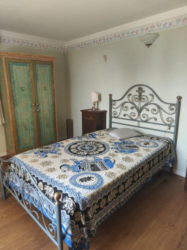 a bedroom with a bed with a blue and white comforter at Casa del sole in Rivarotta