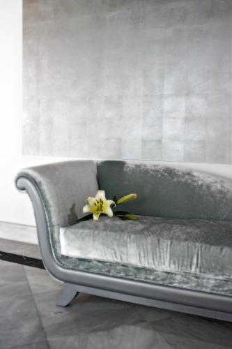 a gray couch with a yellow flower on it at Hospes Palacio del Bailio, a Member of Design Hotels in Córdoba