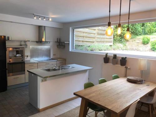 une cuisine avec une table en bois, une table et une fenêtre dans l'établissement GRANDE MAISON COZY, SUD, 15 MIN SPA FRANCORCHAMPS, à Theux
