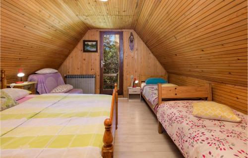 a bedroom with two beds in a wooden cabin at 1 Bedroom Awesome Home In Zlobin in Zlobin