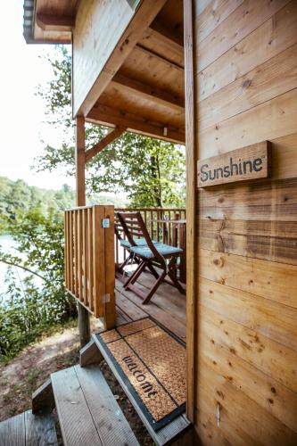 a wooden cabin with a bench on a deck at Riverland in Gornji Zvečaj