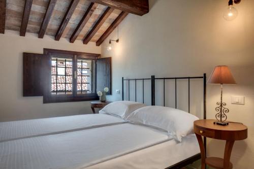 バルドリーノにあるRambaldi Apartments Casa nr 1のベッドルーム1室(ベッド1台、テーブル、窓付)