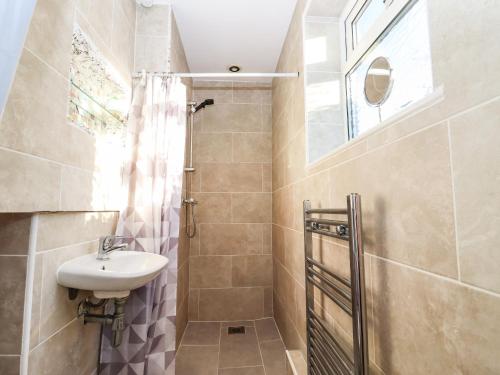 een badkamer met een wastafel en een douche bij Bay Cosy in Pevensey