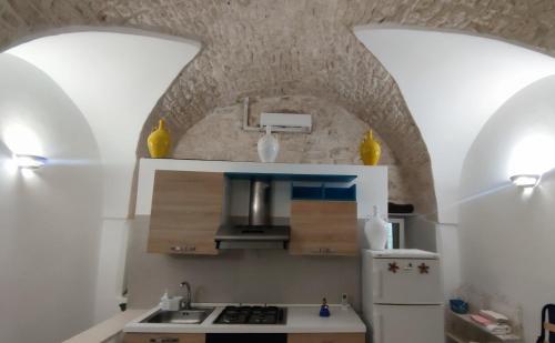 cocina con 2 techos abovedados y nevera blanca en Maison Matilde, en Ceglie Messapica