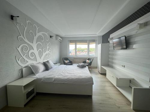 1 dormitorio con 1 cama blanca y TV en Cluj Napoca Apartament Lux Cuza Voda, en Cluj-Napoca