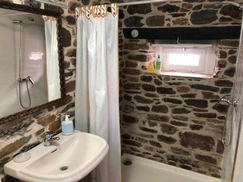 een badkamer met een wastafel en een stenen muur bij Casa do Hiebra Alojamiento Rural Ribeira Sacra 