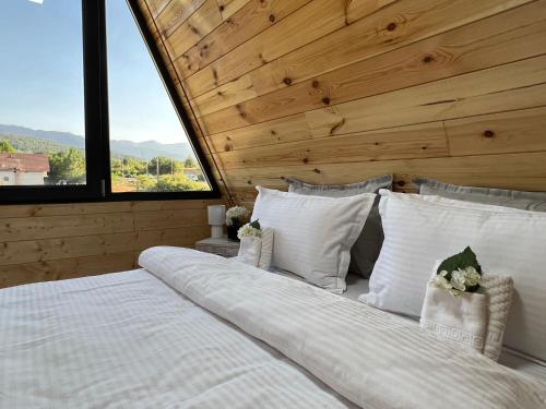 a bedroom with a large white bed with a wooden ceiling at Liniștea Muntilor Cartioasra in Cîrţişoara