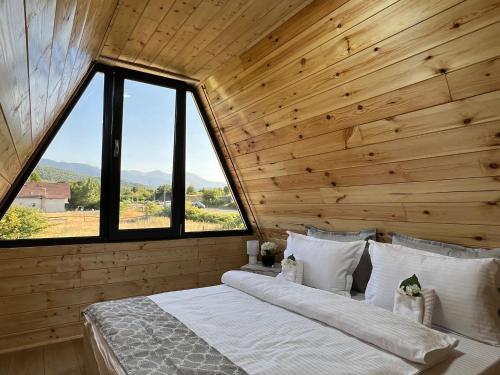 a bedroom with a large bed in a wooden cabin at Liniștea Muntilor Cartioasra in Cîrţişoara