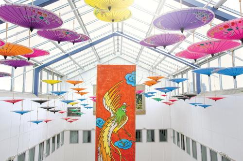 a bunch of umbrellas hanging from the ceiling in a building at 2Home Stockholm South in Stockholm