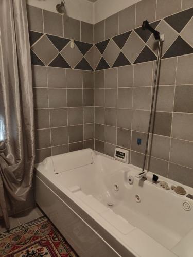 a white bath tub in a tiled bathroom at Casa del sole in Rivarotta