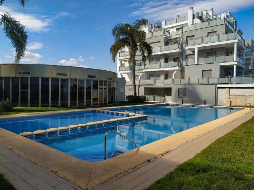 a swimming pool in front of a building at Atico Oliva Nova - MET in Oliva