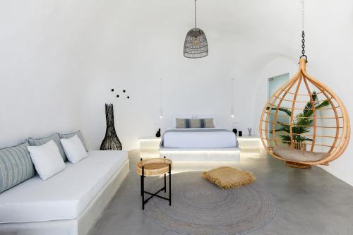 a white living room with a bed and a white couch at U & ME SUITES in Fira