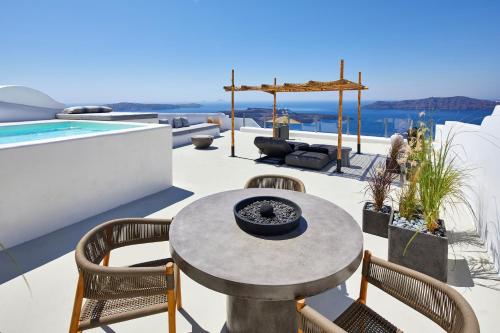 a patio with a table and chairs and a pool at U & ME SUITES in Fira