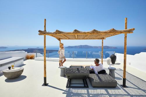 a woman standing on the roof of a house at U & ME SUITES in Fira