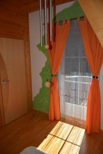 a room with orange curtains and a window at Ferienhaus Kristina/Hebalm in Deutschlandsberg