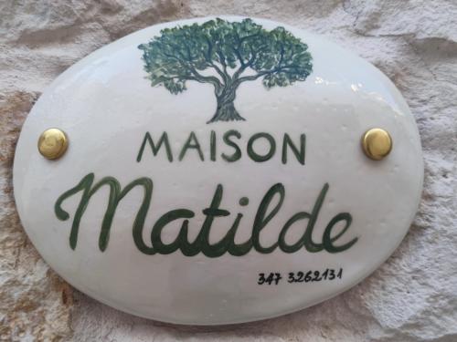 Una señal para un museo con un árbol. en Maison Matilde, en Ceglie Messapica