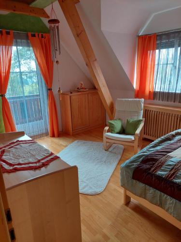 a bedroom with a bed and a chair and windows at Ferienhaus Kristina/Hebalm in Deutschlandsberg