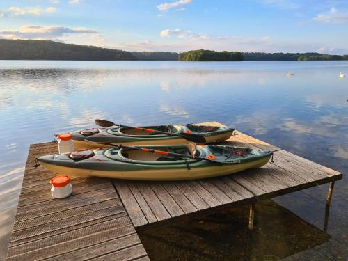 a group of canoes sitting on a dock on a lake at Ferienhaus SeeWaldMeer am Pinnower See bei Schwerin in Pinnow