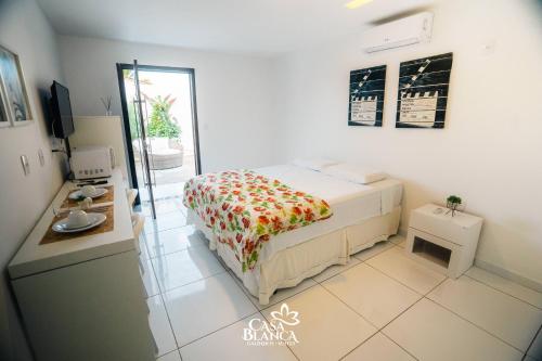a small bedroom with a bed and a kitchen at Casa Blanca in Galinhos