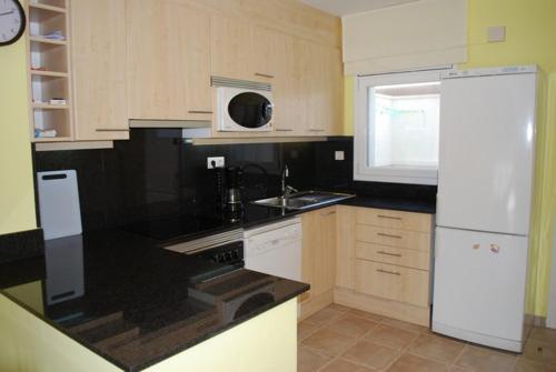 uma cozinha com um frigorífico branco e um lavatório em Duplex Residencial Marina del Port 72 em Calafat