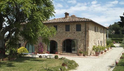 a stone house with a table in front of it at Agriturismo Macinello in Montefiridolfi