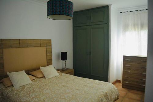 Un dormitorio con una cama y una cómoda y una ventana. en Casa Con Piscina Y Pista De Tenis, en Alhaurín de la Torre