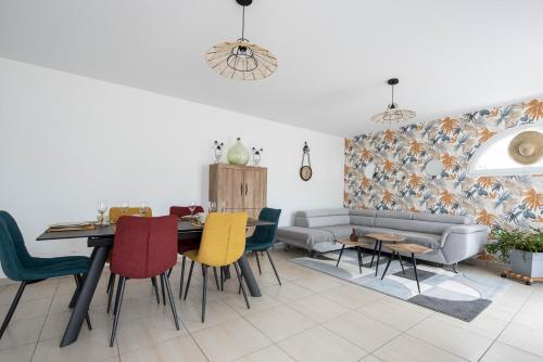 un salon avec un canapé, une table et des chaises dans l'établissement Maison pour 6 entre Marais salants et plages, à Les Bussolleries