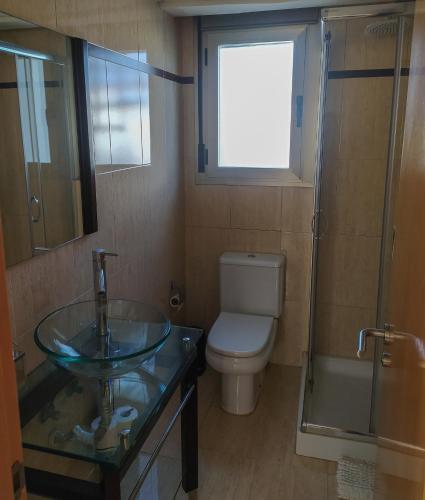 a bathroom with a sink and a toilet and a window at Atico Oliva Nova - MET in Oliva