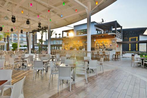 ein Restaurant mit Tischen und Stühlen und eine Bar in der Unterkunft Crystal Family Resort & Spa - Ultimate All Inclusive in Belek