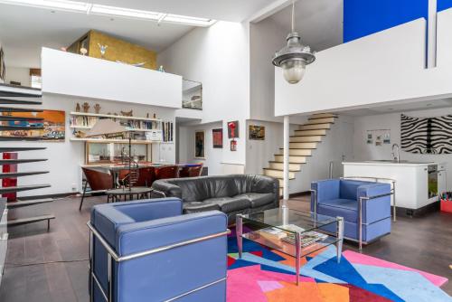 Il comprend un salon doté d'un mobilier bleu et d'un escalier. dans l'établissement Loft d'artiste au coeur du quartier Zola (2 pers.), à Nantes