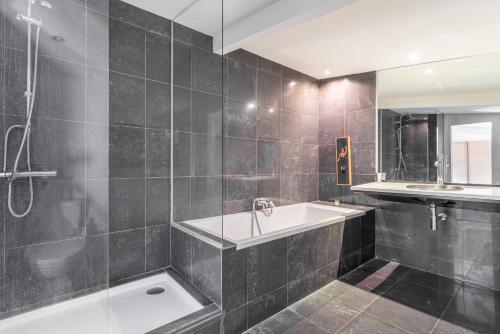 une salle de bain avec une baignoire et un lavabo dans l'établissement Loft d'artiste au coeur du quartier Zola (2 pers.), à Nantes