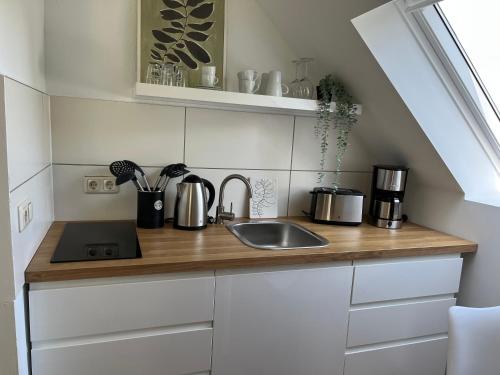 a kitchen with a sink and a counter top at Deich Winde 9.1 in Dorum-Neufeld