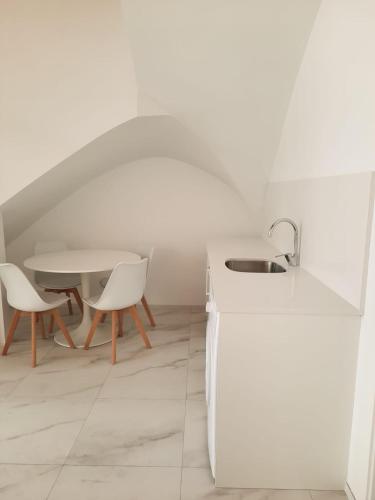a kitchen with a sink and a table with chairs at Termas Romanas Allon by Seaward Suites in Villajoyosa