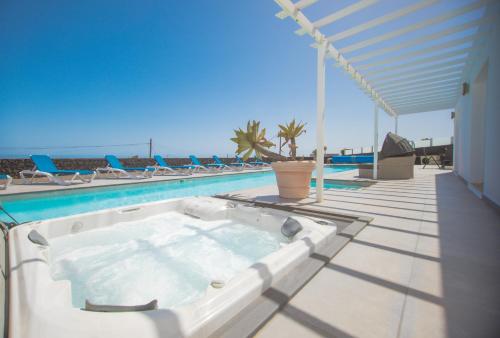 una piscina con bañera de hidromasaje en un patio en Casa Conil with a private 25 meter heated pool en Conil