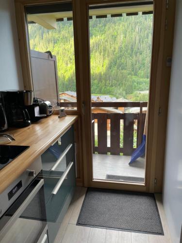 a kitchen with a sliding glass door to a balcony at Charmant appartement 2 pièces - 4 personnes in Châtel