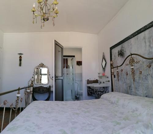 a bedroom with a bed and a chandelier at Otranto Mon Amour in Otranto