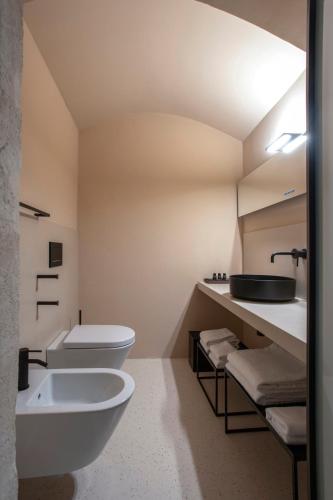 a bathroom with two toilets and a sink at PIANELLE RESORT in Matera